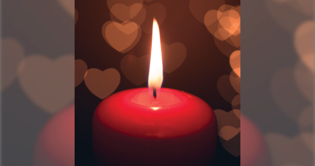 a red candle with a fire on it